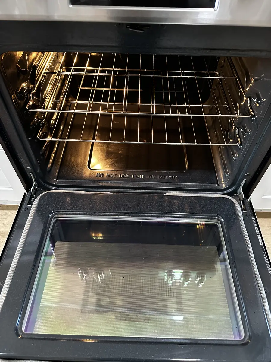 Inside of an oven with clean racks and clear door glass after a deep clean