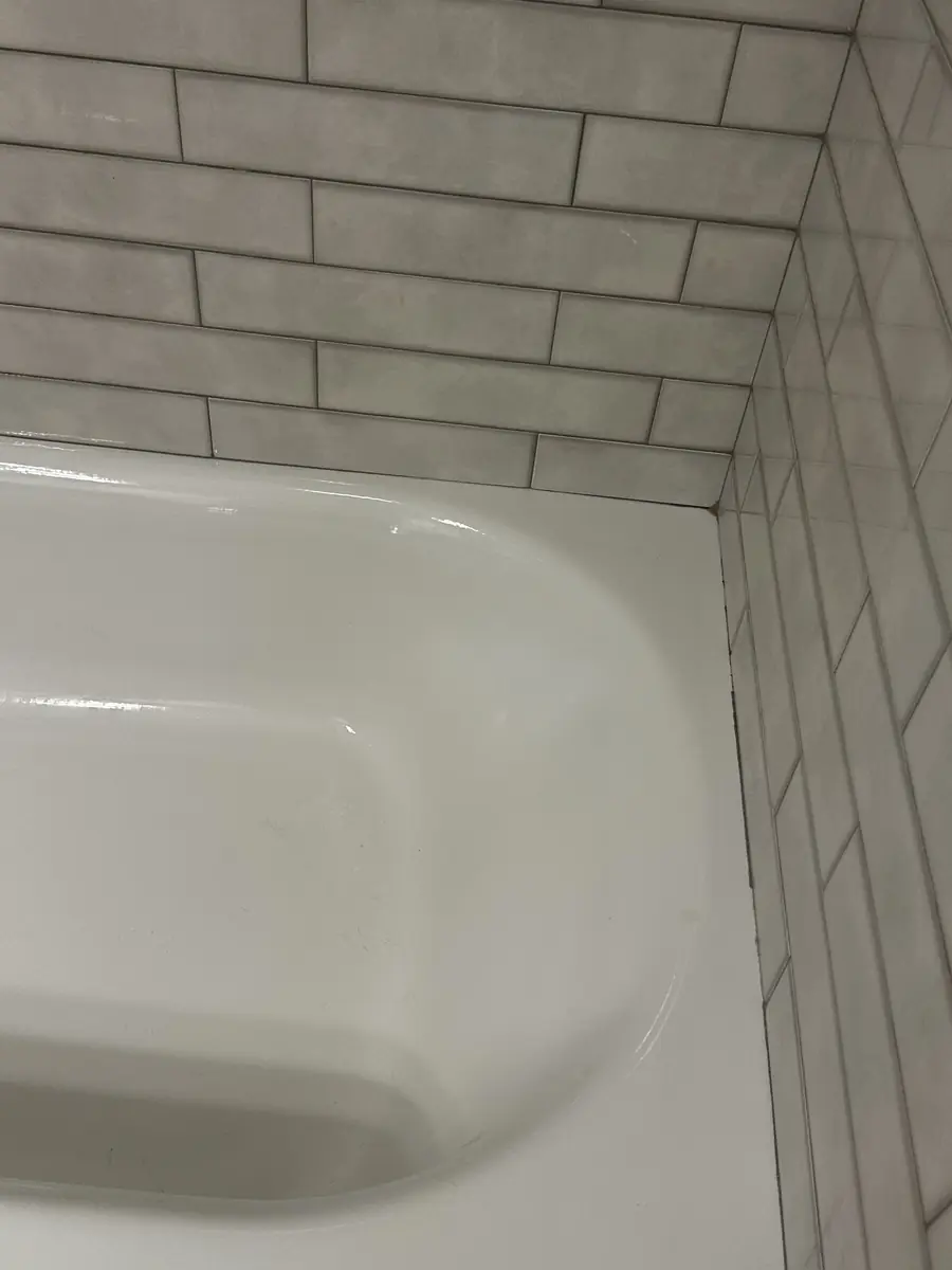 Bathtub and white subway-tile corner, clean and bright after a Cleanera visit